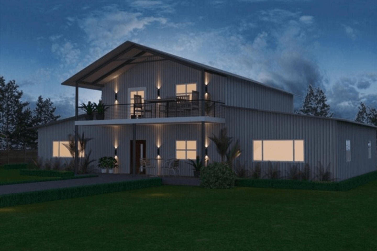 Modern barndominium exterior of steel kit home at dusk with second-floor balcony, warm glowing windows, and landscaped lawn
